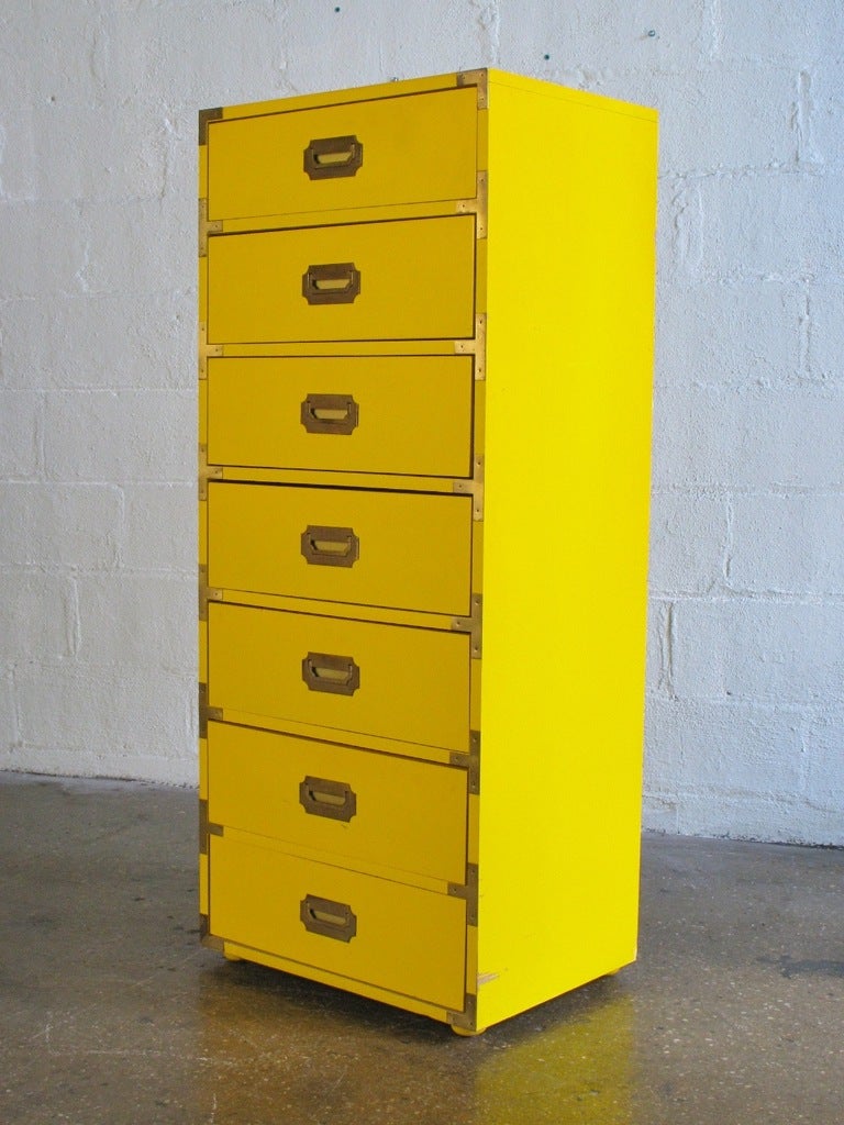 Tall dresser dazzles in exuberant yellow. Quality piece features seven dovetailed drawers and oak hardwood construction. The chest of drawers sits on small bun feet. Campaign-style hardware and drawer pulls are all intact and the metal has a