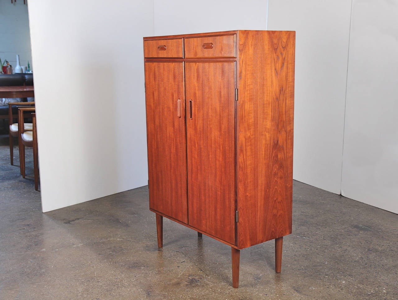 Smart storage. Danish modern tall chest, dressing cabinet, or armoire has two shallow drawers up top and four spacious shelves below. Perfect for the bedroom, living room, or even the kitchen or dining room. Teak shows beautiful tone and grain.