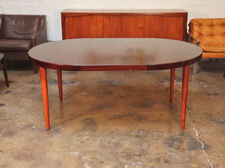 Deep, lustrous rosewood brings warmth and sophistication to this elegant dining table. This 1960s table, with tapered legs and a substantial three-leaf top, expands to seat eight to ten.

Measures: Approximately 45.5" in diameter with no