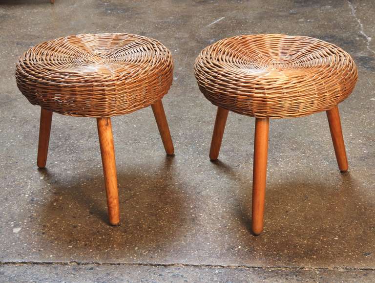 Perfectly proportioned mid-century stools designed by Tony Paul. Rattan seats, walnut legs. Use as stools, footrests, or grab-and-go tables. One seat has slight concavity due to age; both stools are sturdy, fully functional, and handsome. 1950s. In