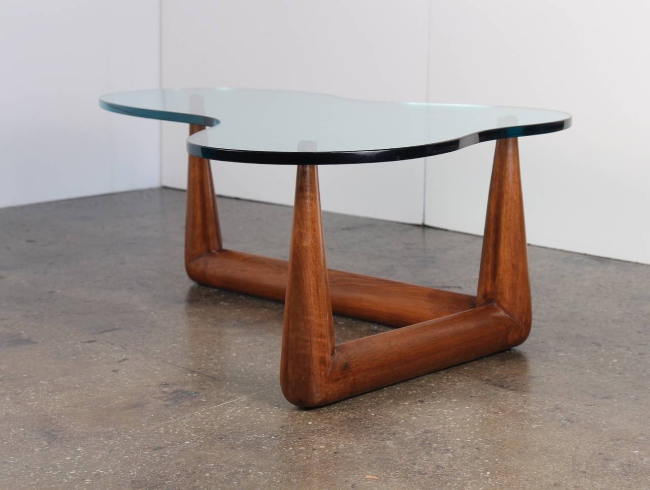 Incredible sculpted walnut base supports a biomorphic glass top in exquisite condition. The 5/8