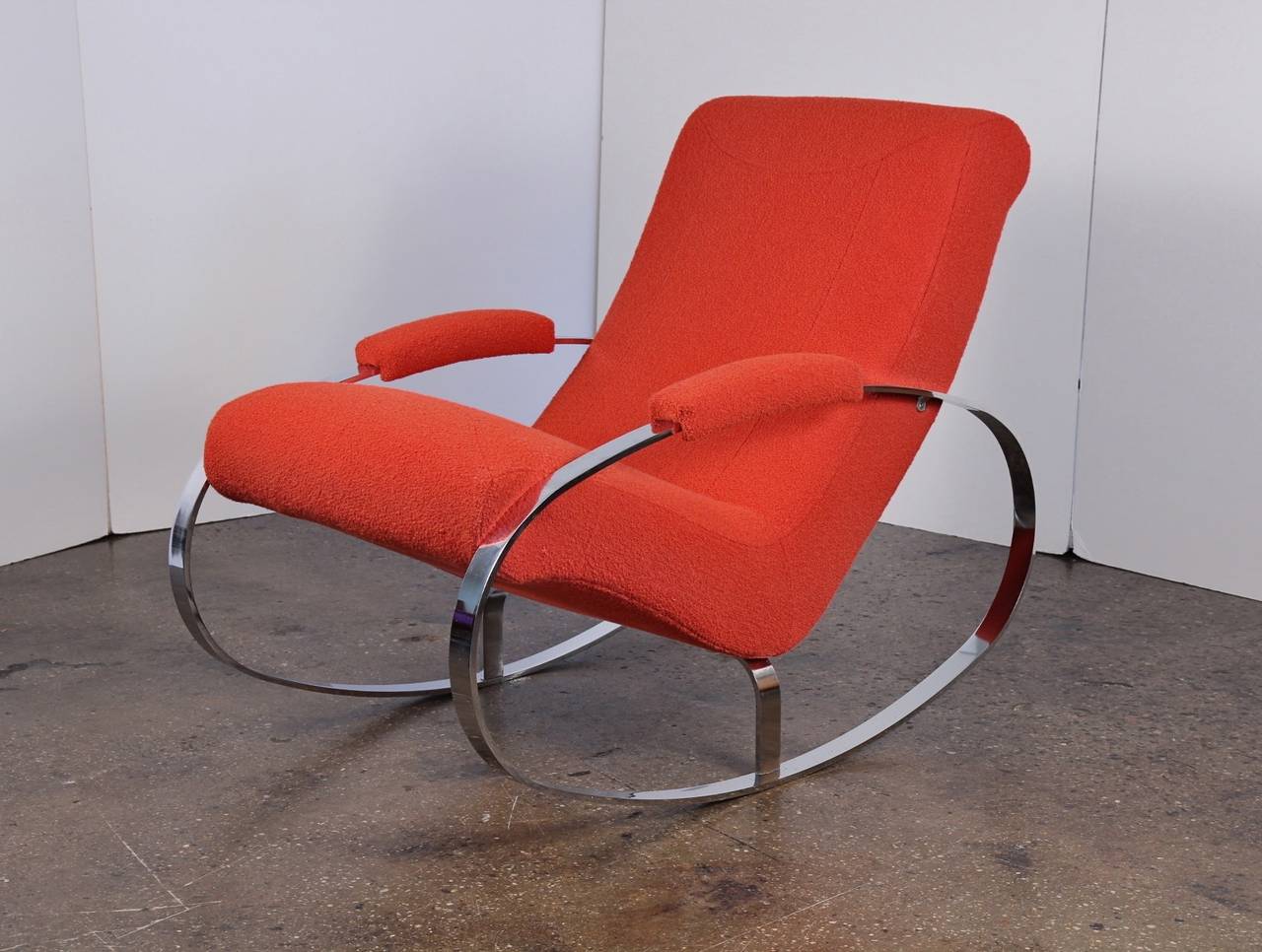 This Milo Baughman-style rocking chair reinvents the form with sleek chrome hoops and stripped-down minimalism. It's just about the most mod rocker we've ever seen! Newly upholstered in Knoll fabric (Classic bouclé́ in Crimson-- a soft coral, much