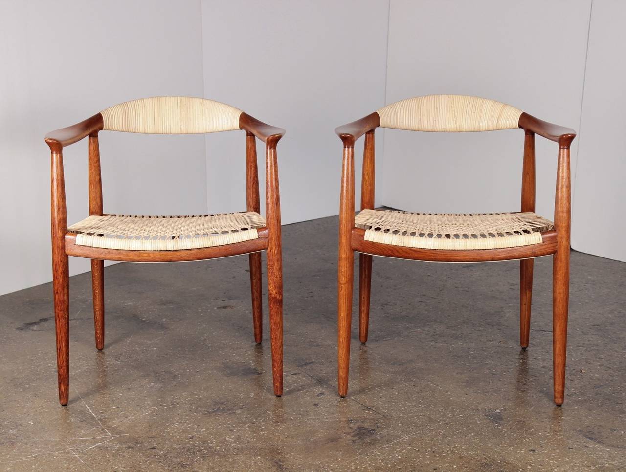 Lovely pair of oak and cane round chairs by Hans J. Wegner. Model JH 501. The chairs have been meticulously restored, with new caning and a hand-rubbed oil finish. They maintain their exquisite 1950s patina and are in excellent condition. The oak's