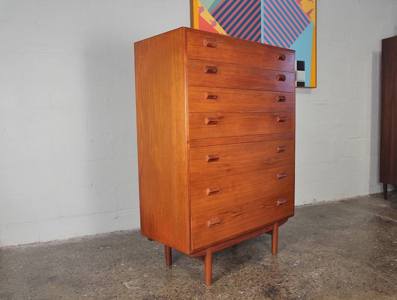 Lovely Danish modern teak tallboy dresser. This large-scale piece has abundant storage in its seven drawers. We have additional matching storage pieces that form a suite: a vanity and a four-drawer dresser. Designed by Borge Mogensen. Povl Dinesen