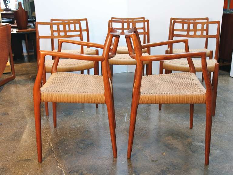 Sculptural teak dining chairs designed by Niels O. Møller for his J.L. Møller Møbelfabrik in 1966. The six side chairs (Model 79) and two armchairs (Model 64) illustrate Møller's incredible talent and instinct for organic design. This rare set of
