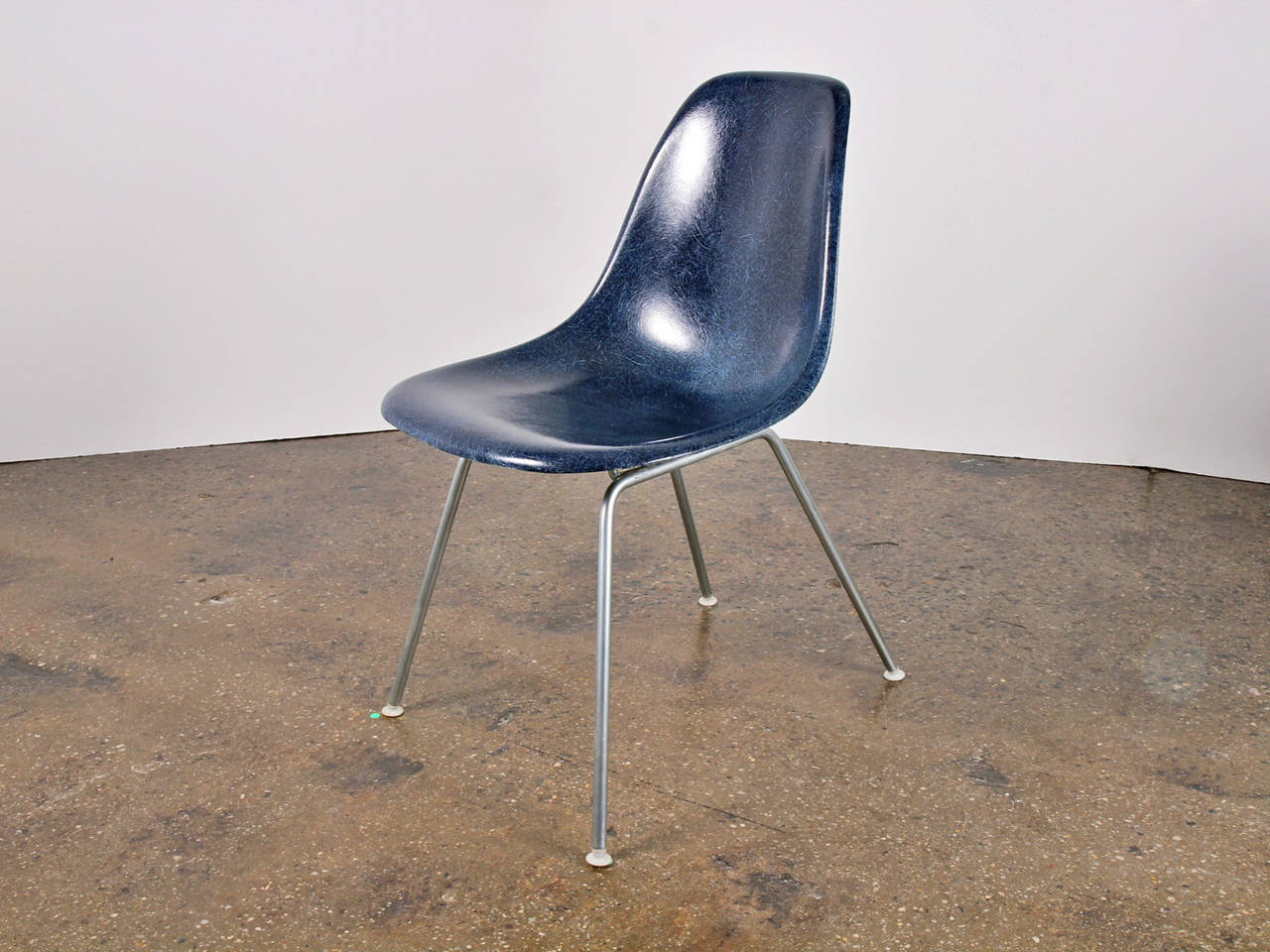 Chaises originales en fibre de verre moulée des années 1960 en bleu marine, conçues par Charles et Ray Eames pour Herman Miller. Les coquilles brillantes sont en état d'origine, chacune ayant une texture filiforme distincte.  Montré ici monté sur