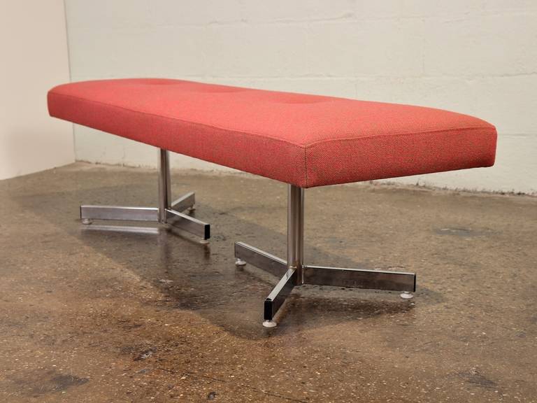 An elegant upholstered bench with a double tripod base. Subtle button-tufting detail. Newly reupholstered in Hallingdal, designed by Nanna Ditzel in 1965, in a red and khaki colorway. New foam. Chrome is nice and shiny. A great piece for foot of the