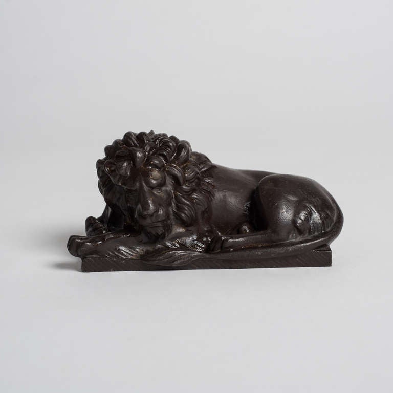 Small sculpture of a seated lion in iron.