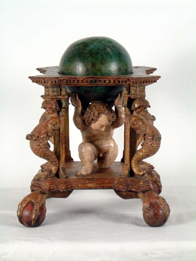 A putti holding the sphere.
On a carved and giltwood stand.
The cpnstellations are rubbed off.