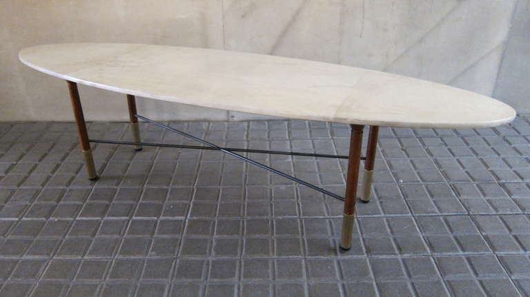 An oval parchment centre table. Wood legs and brass castors. Italy 1960.