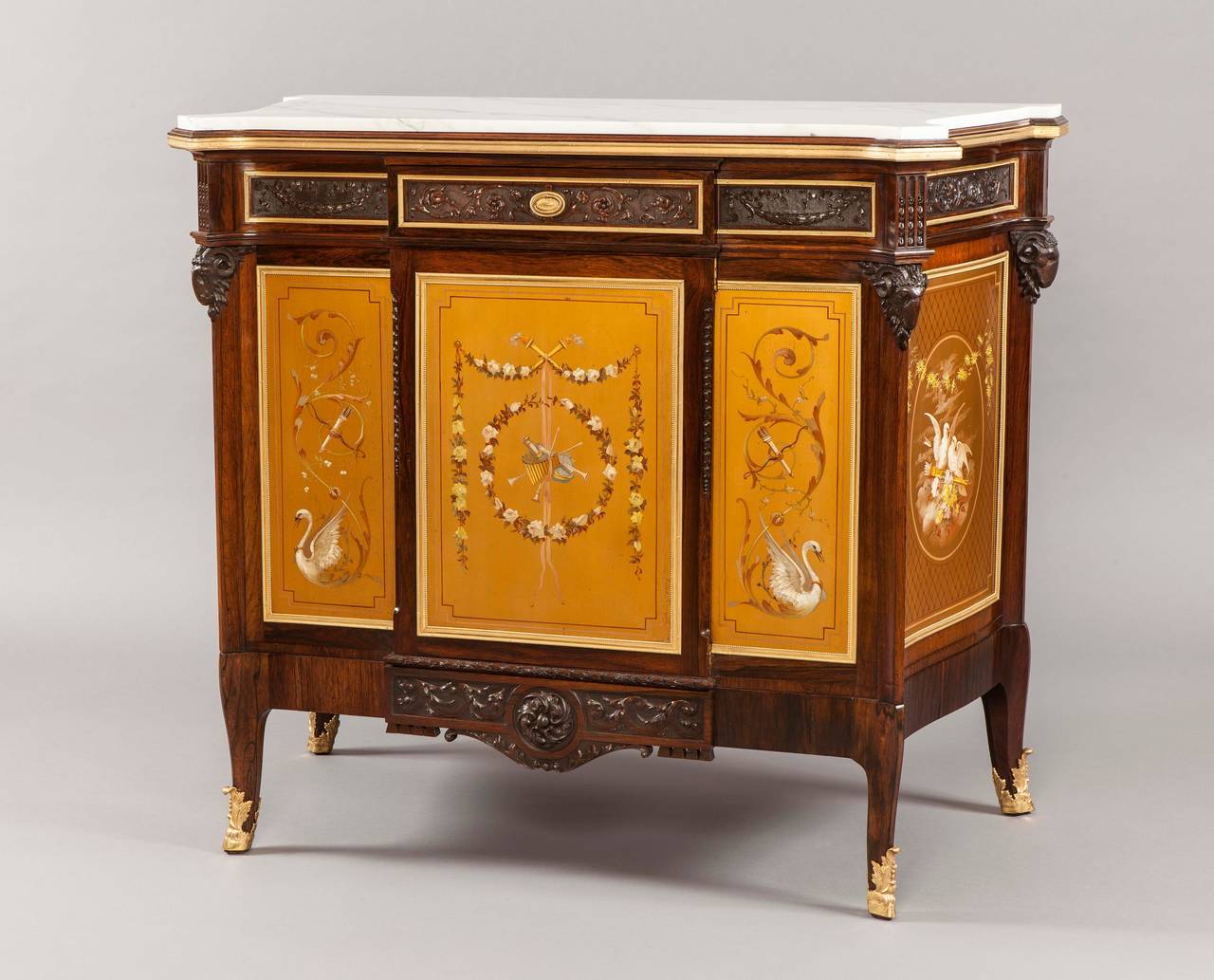 A cabinet in the Louis XVI manner by James Shoolbred and Co of London

Of gentle breakfront form, constructed in goncalo alves, dressed with gilt metal mounts and hand decorated polychrome panels; rising from swept cabriole legs shod with gilt