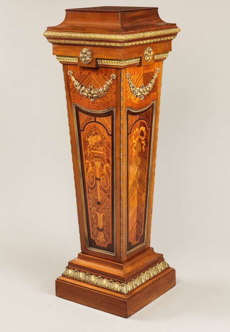 A Kingwood and Mahogany Inlaid Ormolu Mounted Pedestal in the Louis XVIth Manner 

The inset top platform above an ormolu mounted frieze with centre ormolu mounts of fruit and flowers above the tapering column, inlaid with classical motif and