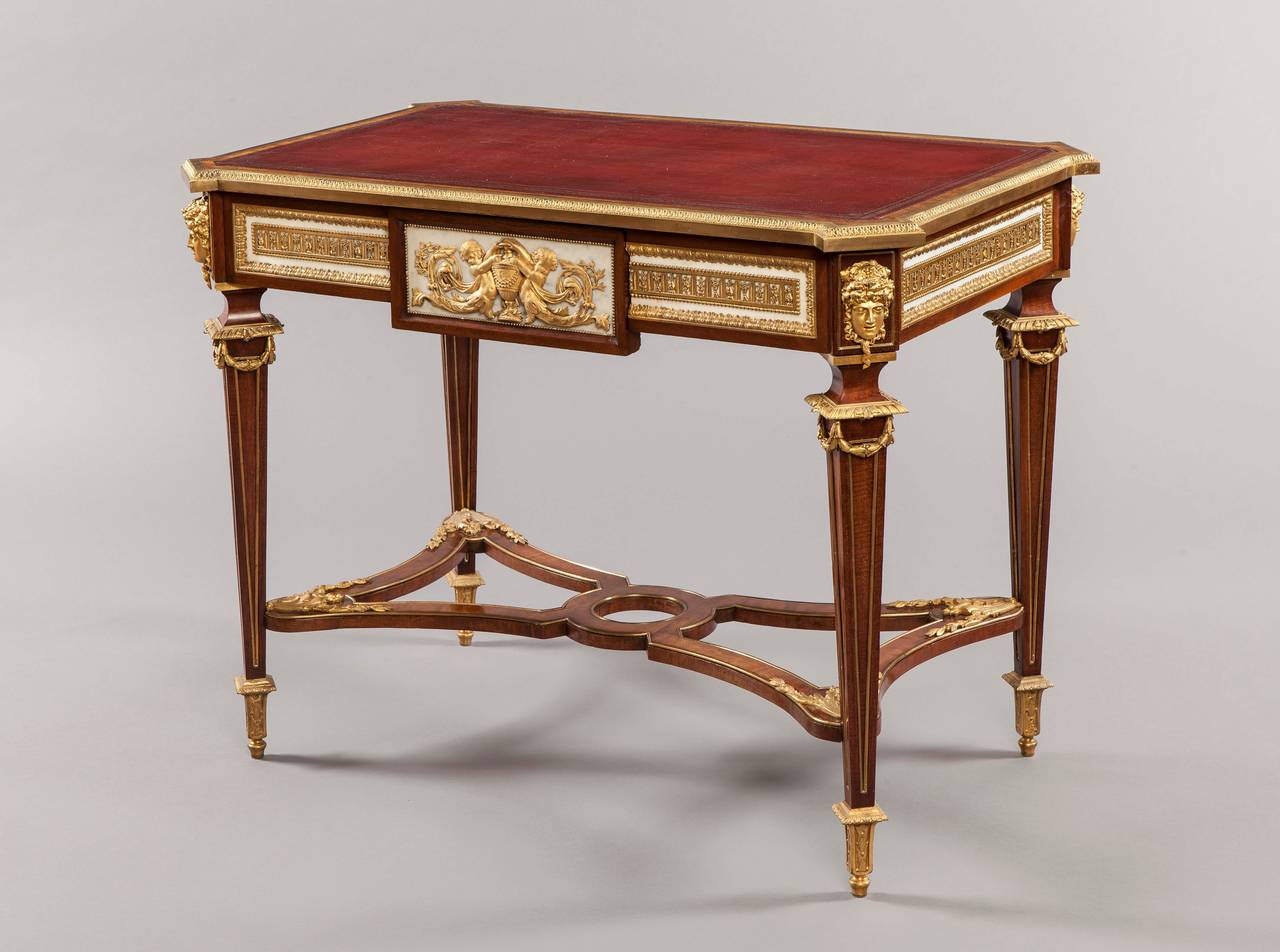 A bureau plat in the Louis XVI manner

Constructed in mahogany, Carrara marble, and extensively dressed with fine ormolu mounts; of freestanding rectangular form, rising from fielded panel tapering legs terminating in foliate chased toupie feet,