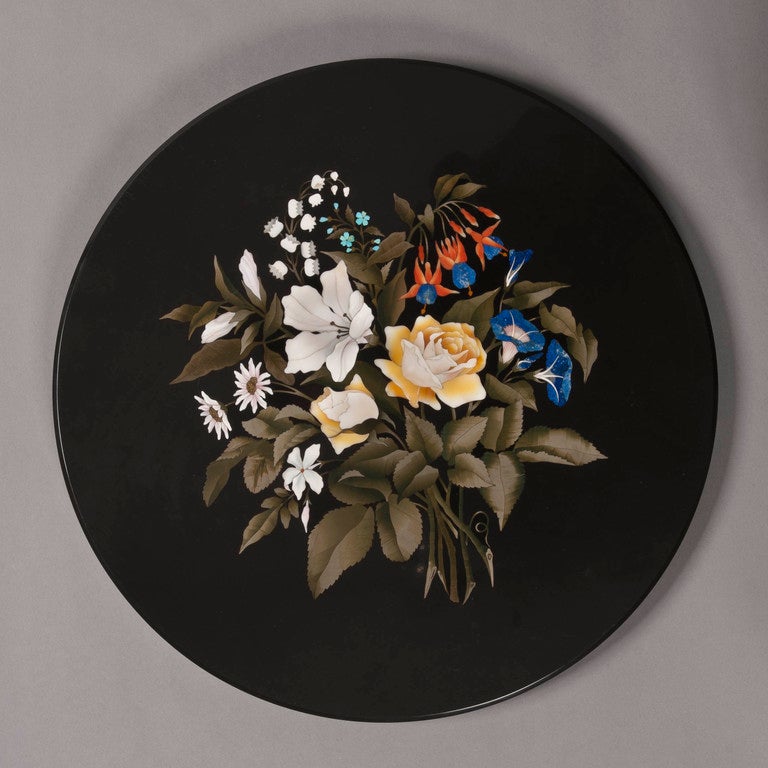 The circular pietra dura inlaid top depicting a bouquet of flowers including primula, roses, campanula and muguet using a variety of hardstones, including laps lazuli, sienna yellow and verte de mer, enclosed in a gilt highlighted frame with a
