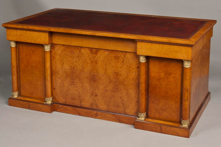 Constructed in particularly well patinated thuyawood veneers over an oak carcass, with bronze embellishments in the style of Percier and Fontaine; rising from a plinth base with a crossbanding of purpleheart, of pedestal nine drawer form, all