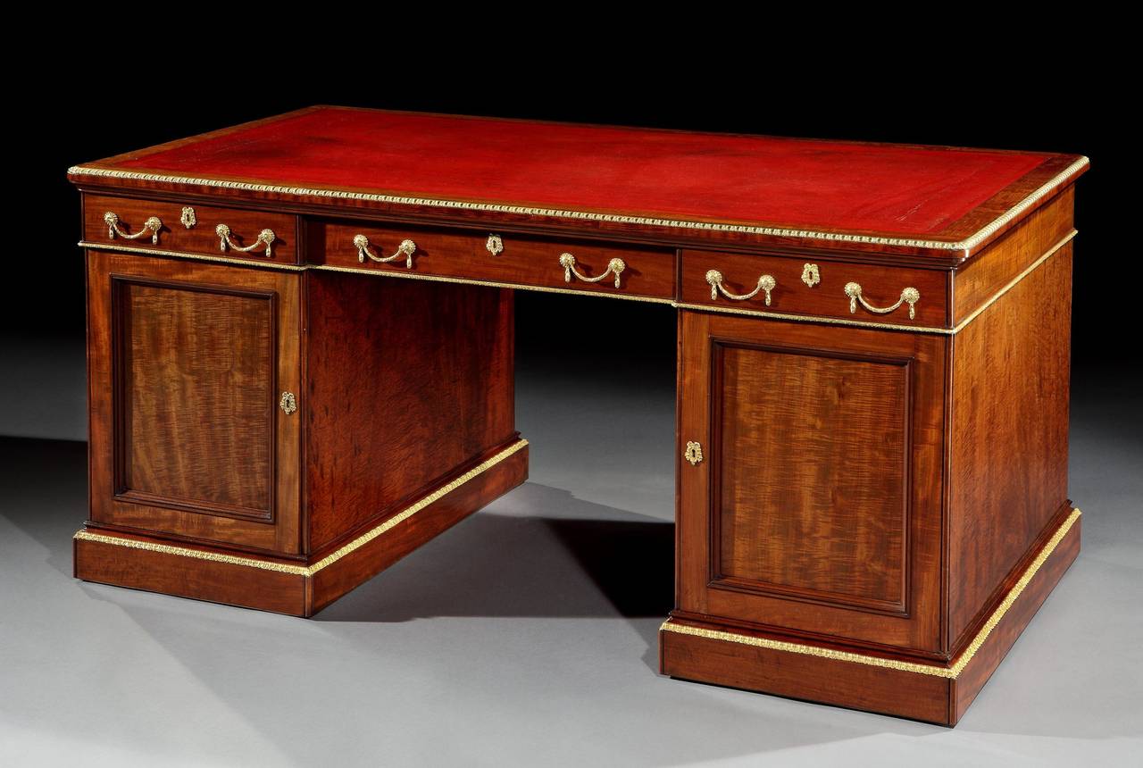 A Very Fine Partners Library Desk by Holland & Sons

Constructed in mahogany and having splendid gilt bronze accents. Of freestanding pedestal form, rising from plinth bases, dressed with running gilt bronze foliate guard bands; having an