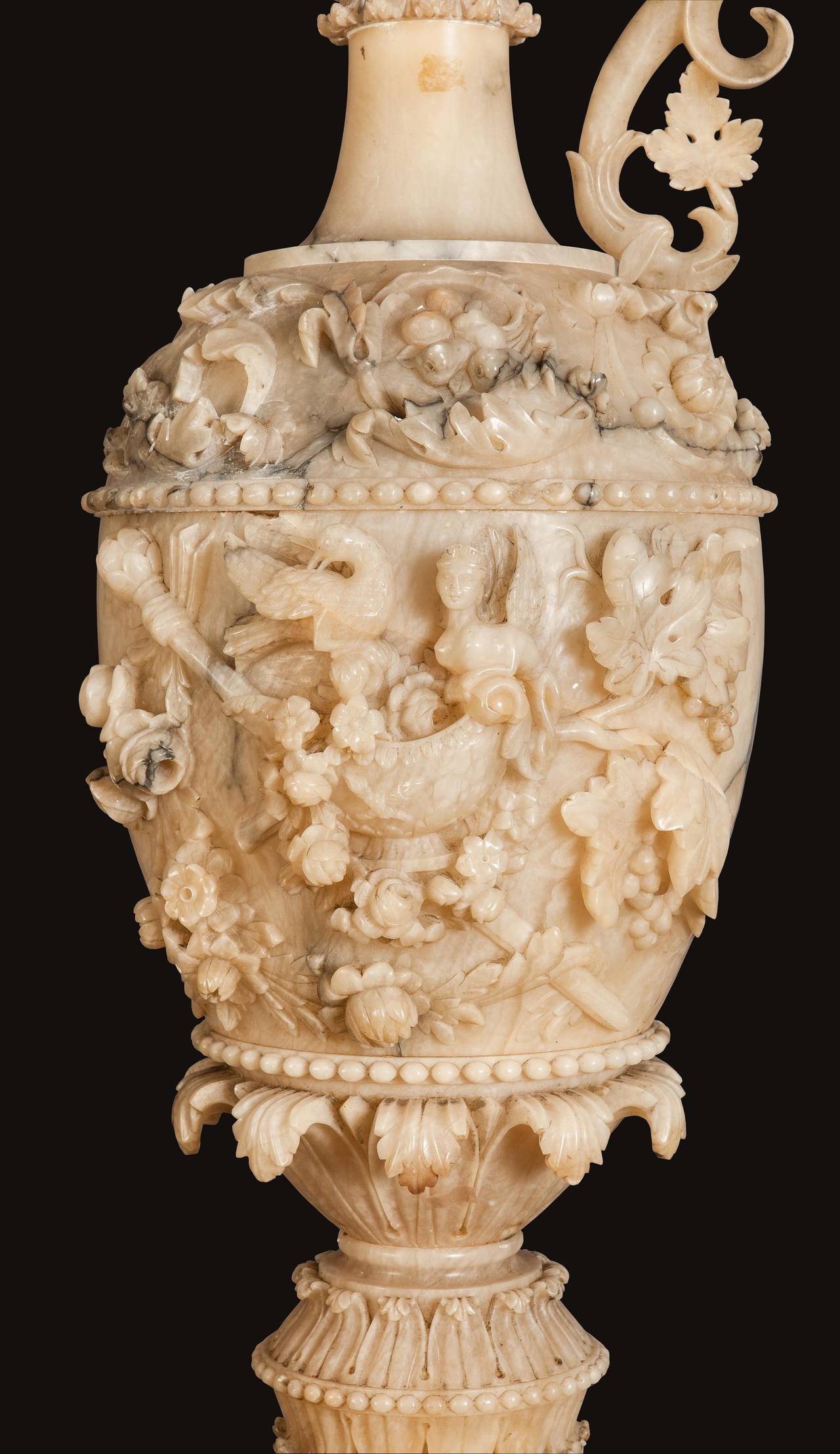 A Pair of Monumental Vases on Pedestals
in the Neo-Renaissance Manner

Constructed in alabaster which has been masterfully carved; rising from octagonal bases, supporting fluted, garland draped pedestals, upon which rest handled ewers, in the