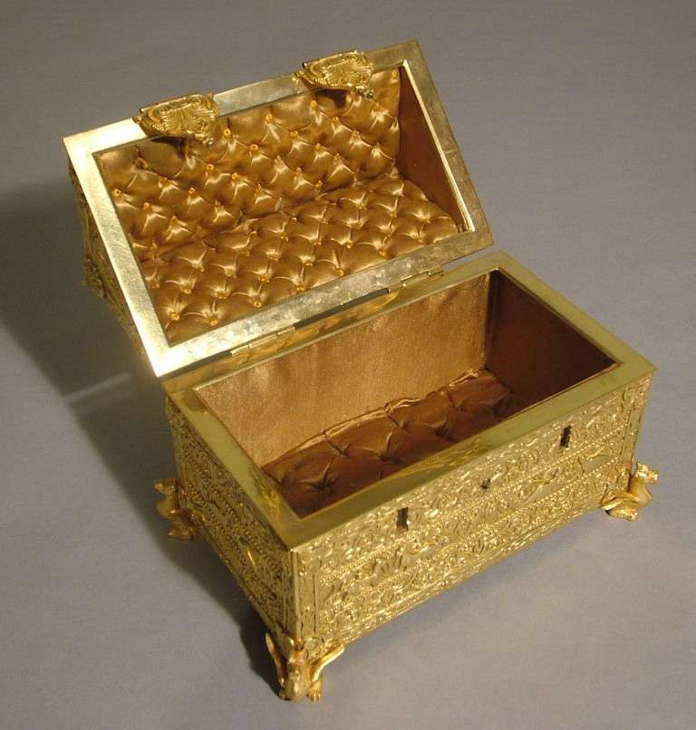 A Fine Antique Jewellery Casket in the form of a 13th Century Limoges Box Reliquary.

Constructed in bronze, and of ‘house’ form, the panels decorated with courtly scenes, and rising from oblate bun feet; two securing hasps, and lockable; the