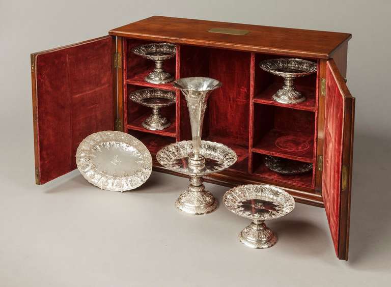 A fine Sheffield hall marked silver cased table service by Frederick Elkington

The seven piece suite comprising;- a tiered epergne, four footed sweetmeat stands and two elliptical trays, embossed with vines, grapes and foliates, all bearing clear