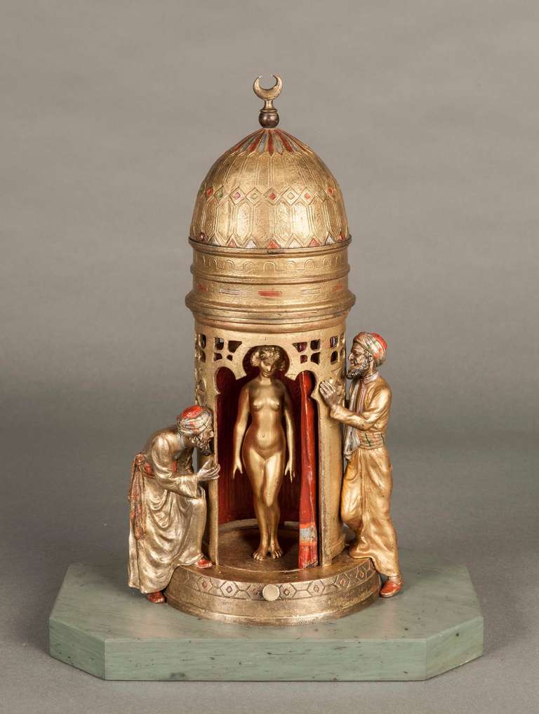 A fine and rare erotic Viennese bronze table lamp by Franz Bergman

The cold painted bronze depicts two slave traders peeping into a tent -like structure erected on a circular base, the domed roof sporting a crescent moon, which, when the spring