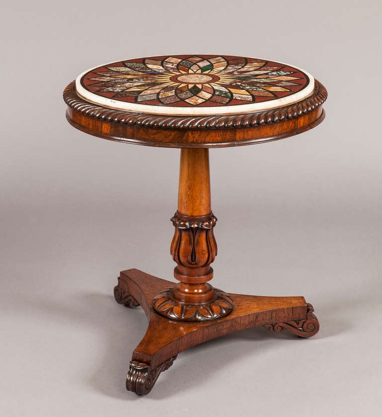 A Fine Late Georgian Occasional Table In the Manner of Gillows

Constructed in a finely patinated figured rosewood, having a Florentine specimen marble top; supported on oblate bun feet, the tripartite and incurved platform base dressed with