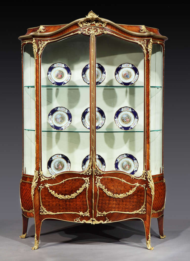 A Display Vitrine in the Louis XV Taste
In the manner of Joseph-Emannuel Zwiener of Paris

Constructed in a distinctively grained and well patinated kingwood, dressed with exuberant ormolu mounts of fine quality; of serpentine form, and rising