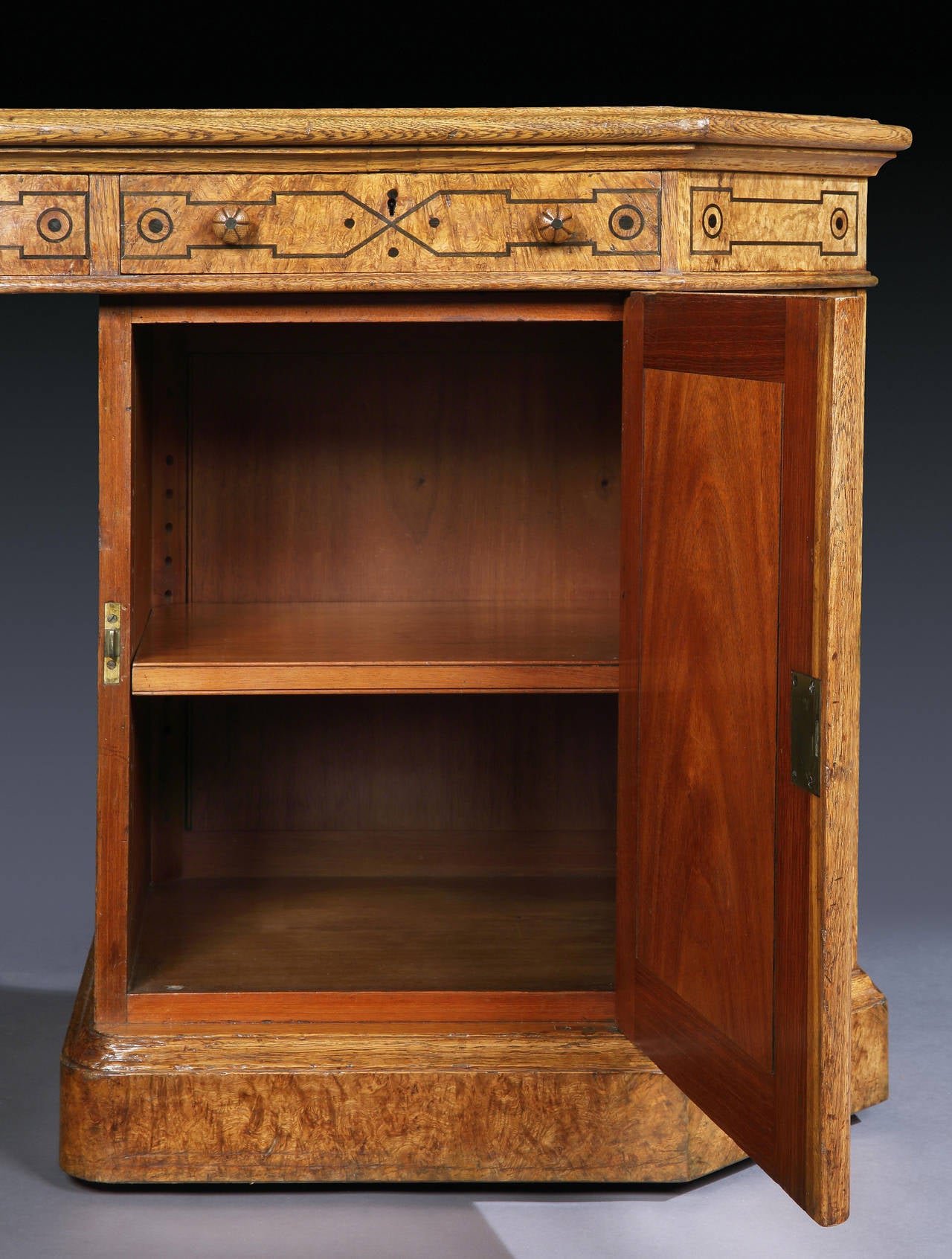 A double partners desk by Johnstone and Jeanes of London.

Of octagonal form, being constructed in pollarded oak, and dressed with line inlays of angular geometric form; the four separate pedestals having fielded panels, are fitted with large