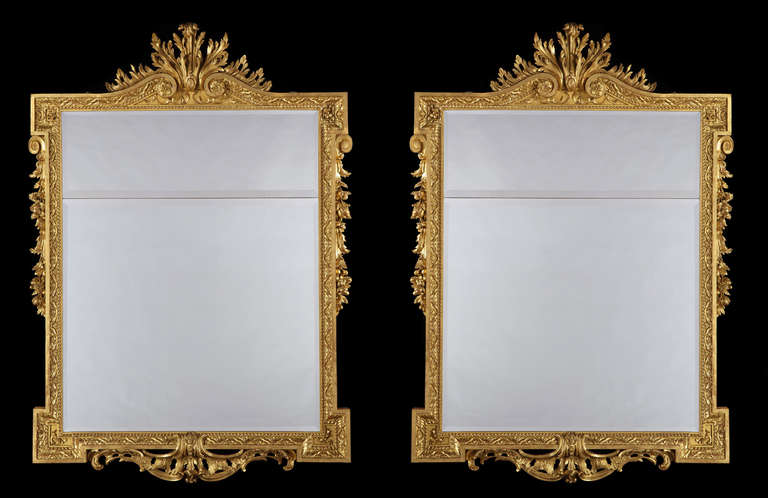 A Pair of Pier Mirrors in the Georgian Palladian Manner

Constructed in carved gilt wood, the portrait form frames of rectangular shape, having everted angles, dressed with fruiting foliates to the sides, clasp work foliates to the bases, with