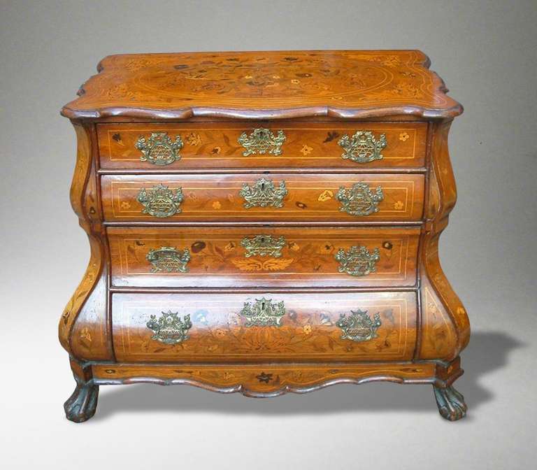 A good Dutch chest of drawers

Constructed in walnut, with an excellent color and patination, having a complex arrangement of inlaid foliate and avian motifs; rising from lions paw feet, supporting a bombe form carcase, with four shaped graduated