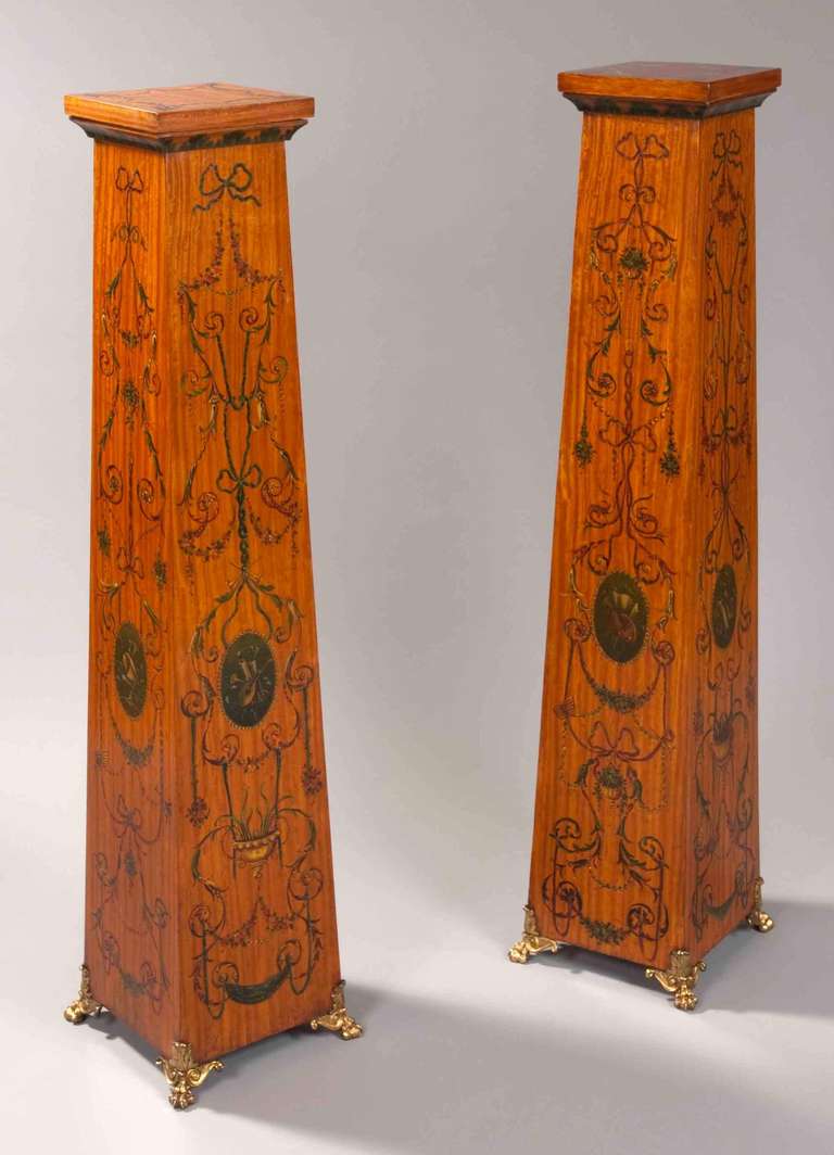A Good Pair of Pedestals in the Neoclassical Manner of Robert Adam

Constructed in Satinwood, of truncated pyramidical form, and extensively decorated in polychromes, with floral swags emanating from elliptical cartouches to each side, displaying