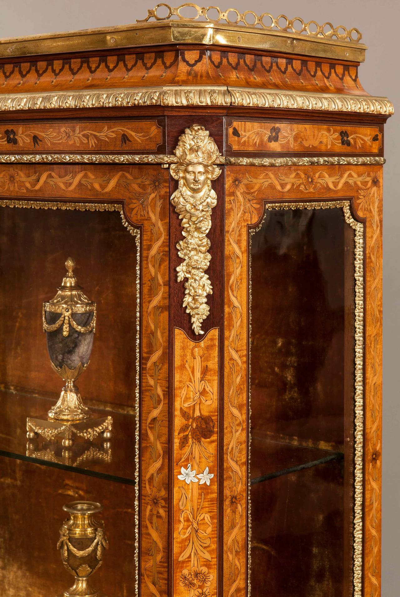 A Mid-Nineteenth Century Vitrine Cabinet 
Attributed to Holland & Sons

Constructed in satinwood, with kingwood cross banding, marquetry inlay in specimen woods, and dressed with ormolu mounts; rising from swept cabriole legs, having foliate sabots