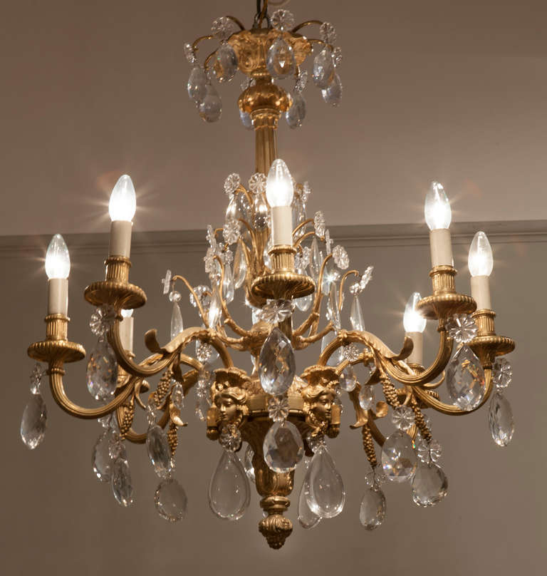 A very fine chandelier in the Louis XV taste. 

Constructed utilizing finely cast, and chased gilt bronze, and handblown glass adornments and prisms of cut lead glass crystal; the framework emanates from a central cannellure column, with a foliate