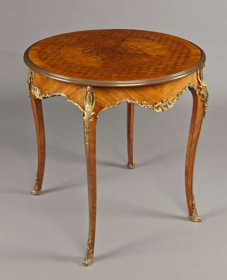 A Good Centre Table in the Louis XVth Manner 

Constructed in Kingwood, with fire gilt bronze mounts of fine colour and quality: rising on cabriole legs, with bronze sabots and guard strips, with foliate bronze spandrels; the ogee shaped bronze