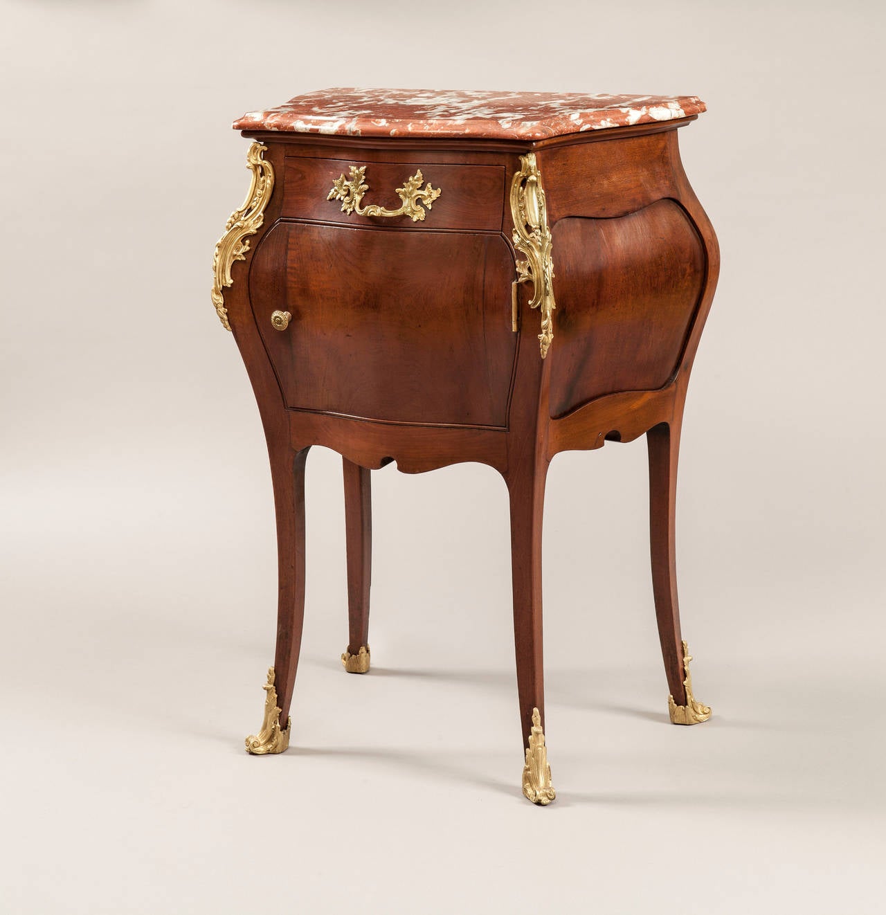 Pair of bedside cupboards in the Louis XV manner

Of shaped form, being constructed in mahogany, with gilt bronze accents, rising from cabriole legs, dressed with gilt bronze sabots and espagnolettes; the corps of bombe form, with fielded panel