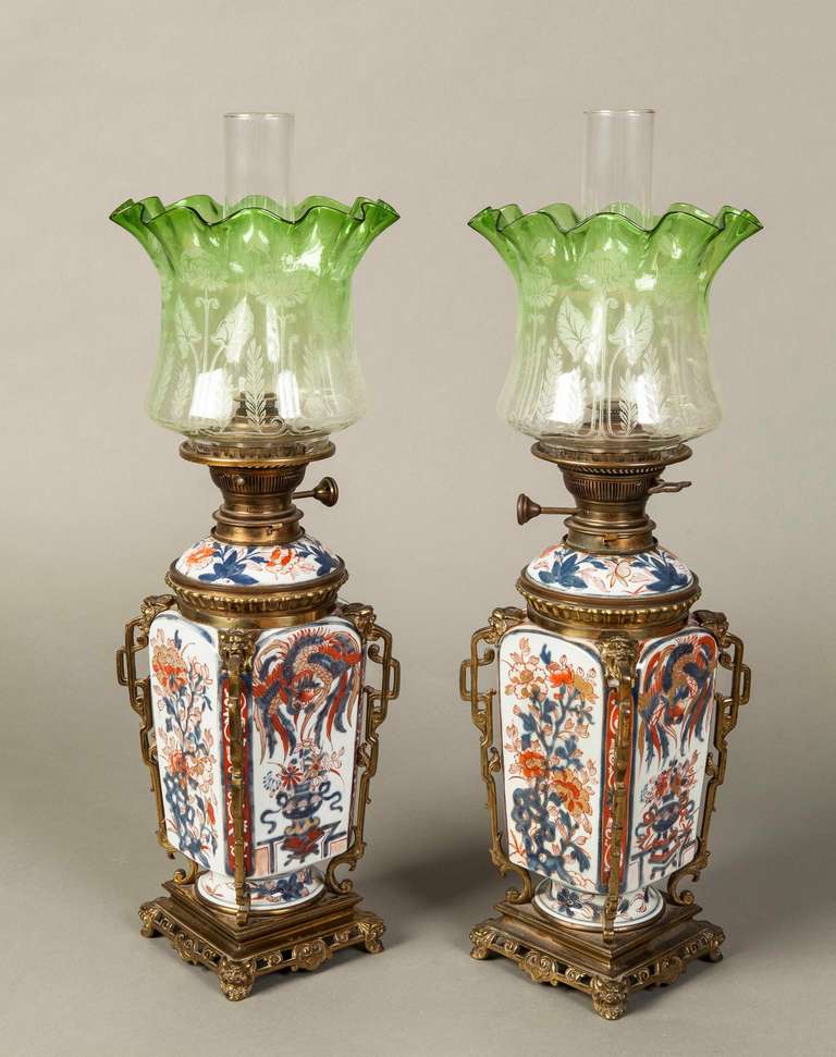 Constructed using a pair of lidded Japanese Imari vases, of square and waisted form, with bronze mounts and accents in the ‘Japonisme’ oriental taste, which were added in France, and utilised to serve as oil lamps, with clear funnels, and green