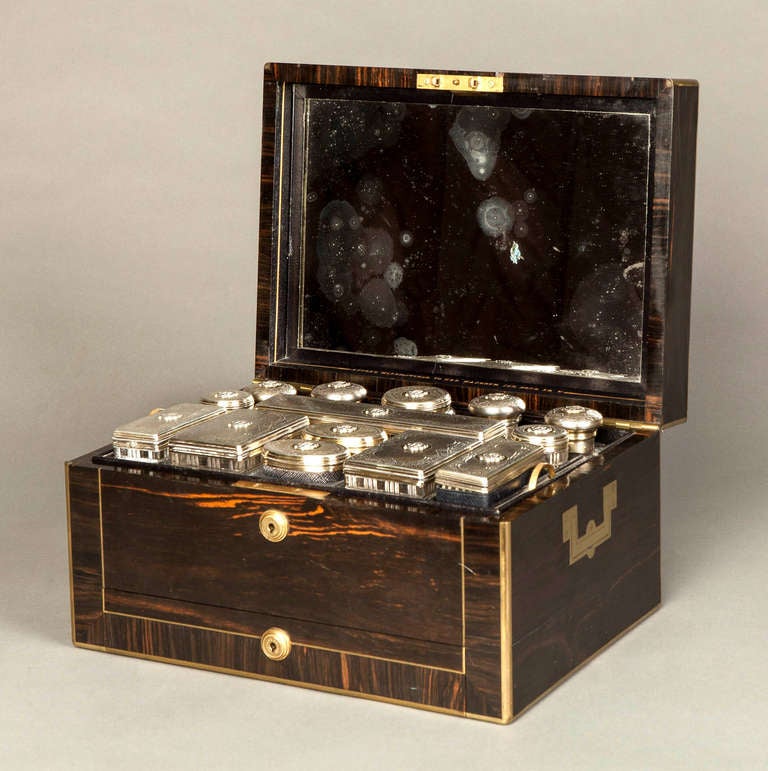 A Victorian Coromandel and Brass bound Dressing Case 
By Asprey

The hinged cover with an inset brass monogram, the base with a jewellery drawer and two fitted internal trays, containing silver gilt mounted fittings, each engine turned and engraved