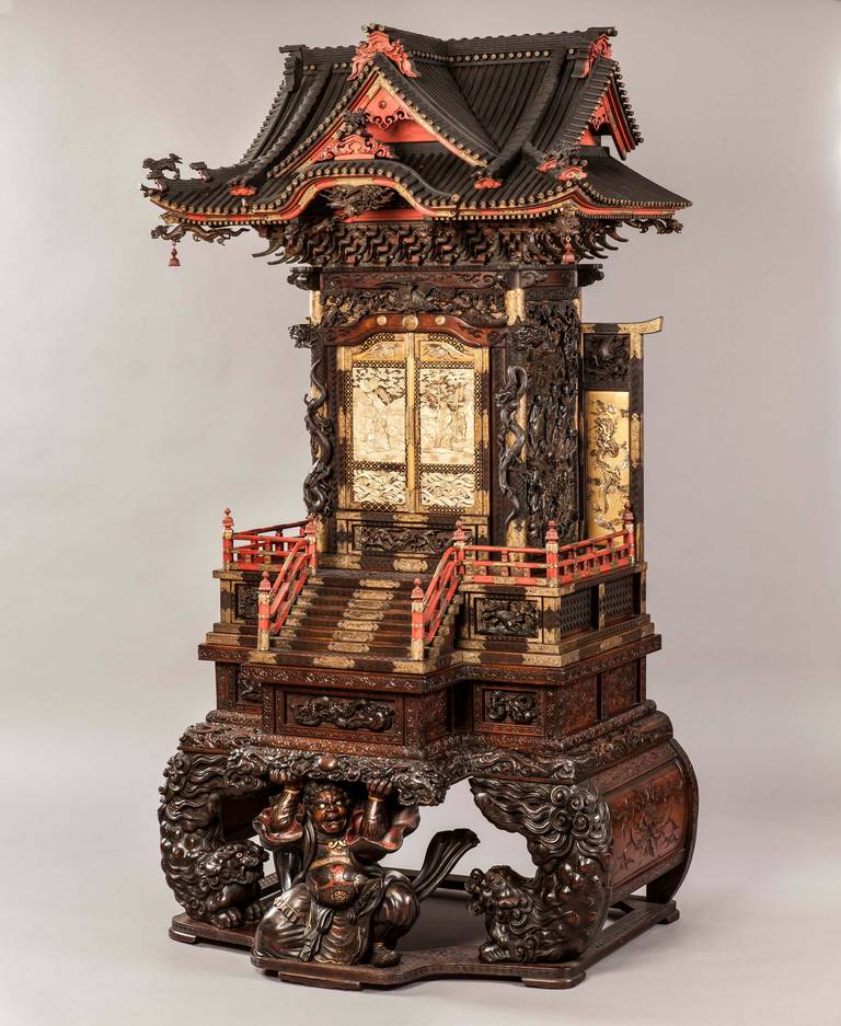 Constructed in three sections, using wood, lacquered in part, and decorated with ivory and Shibayama inlays; rising from a finely carved base in the form of a Yamabushi priest supporting the whole, flanked by a pair of frolicking Karashishi and