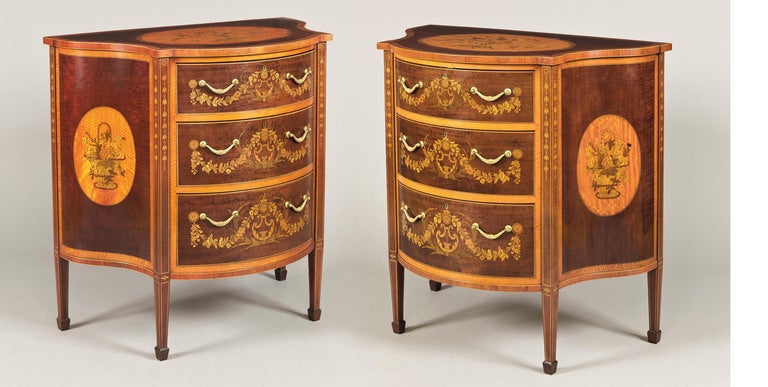 Constructed in fiddleback mahogany, with kingwood crossbanding, and employing exotic woods, such as satinwood and holly in the complex inlay work: of arc-en-arbalette form, the tapering spade footed legs being inlaid with pendant Bellflowers; the