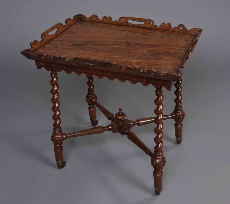 Constructed in goncalo alves, the platform having a shaped and scalloped top, and supported by torsade legs with castors at the base: having a ring turned ‘X’ form stretcher with a central finial.