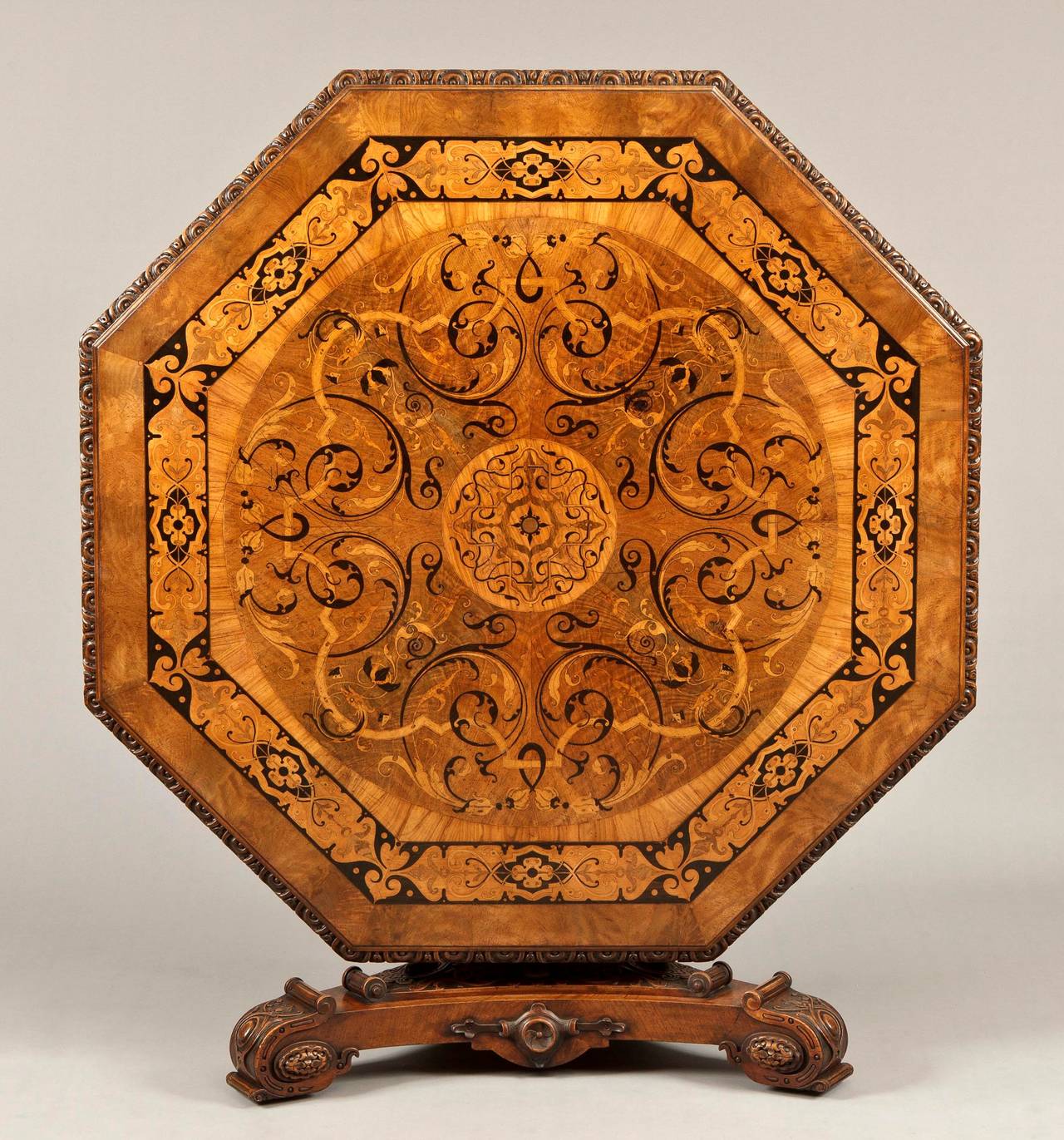 An outstanding centre table labelled James Winter & Sons, 
Wardour Street, London
Of octagonal form: constructed in a finely marked Circassian walnut, carved, and with arabesque inlays in primarily ebony, and specimen woods; the tripartite