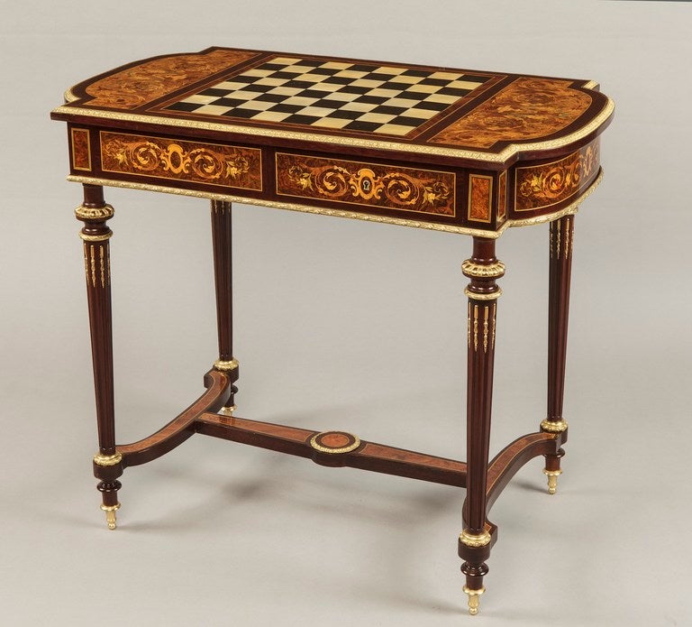 Constructed in Thuyawood, with marquetry inlays and cross banding in Bois Violet, Kingwood  several other exotic woods being employed in the complex arabesque inlays, dressed with gilt bronze mounts; rising from turned, bronze collared and tapering