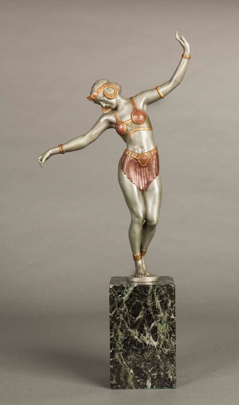 A good silver patinated and cold painted figure, wearing anklets, bracelets and a diadem, standing on a Vert de Mer marble base. The figure marked ‘Made in France’.
