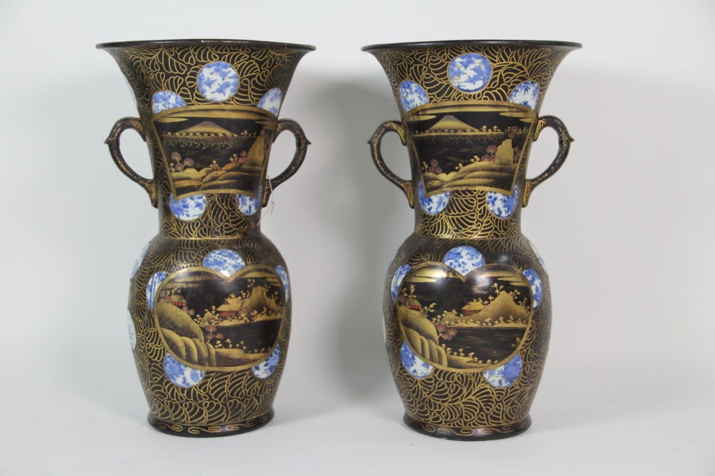 A pair of Arita blue and white porcelain and black and gold lacquer vases.