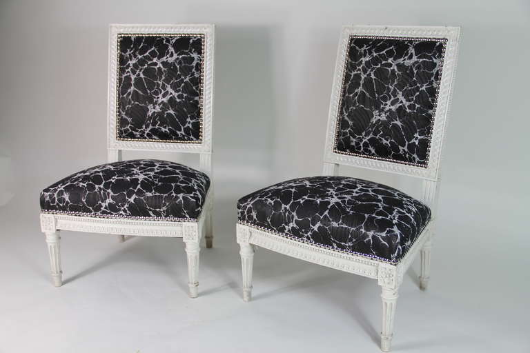 A pair of painted Louis XVI style low chairs upholstered with Rubelli fabric
