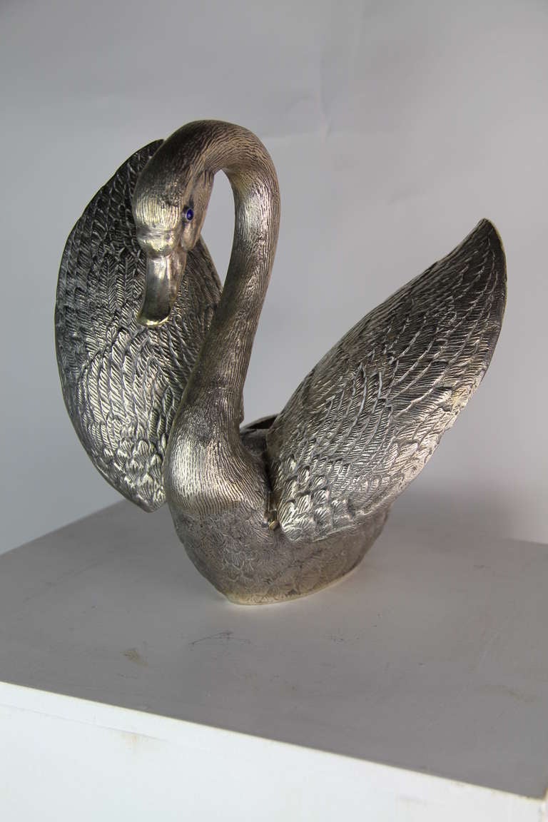 A silver plated metal candy bowl in the shape of a swan with glass eyes.