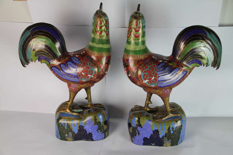 A copper and cloissoné enamel pair of cocks on stands
