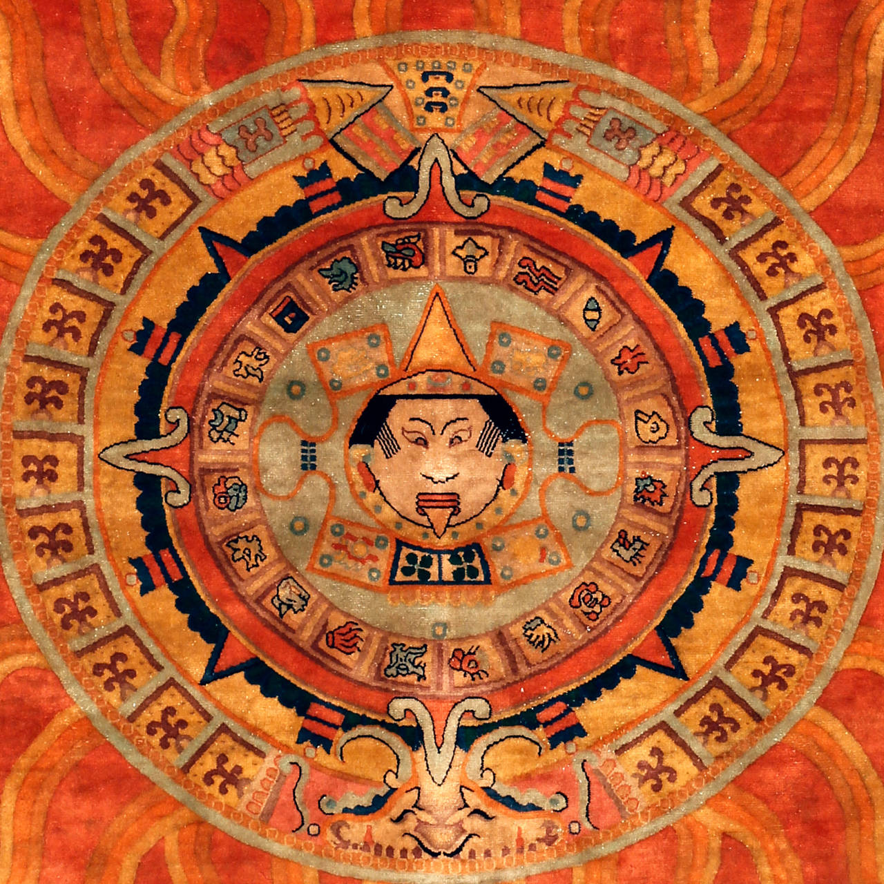 Dieser ungewöhnliche quadratische Teppich, der vor einigen Jahren in China beschafft wurde, stellt die Symbolik der aztekischen Sonnenuhr dar. Diese sind in Kreise eingeschrieben, in deren Zentrum ein menschliches Abbild steht, möglicherweise die