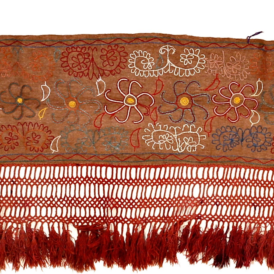 A rare complete tent band, embroidered in wool on a felt background, embellished at its bottom by polychrome tassels. The Kirghiz people of Central Asia employ bands such as this to ornate the interior of their tent, the yurt, which they use as