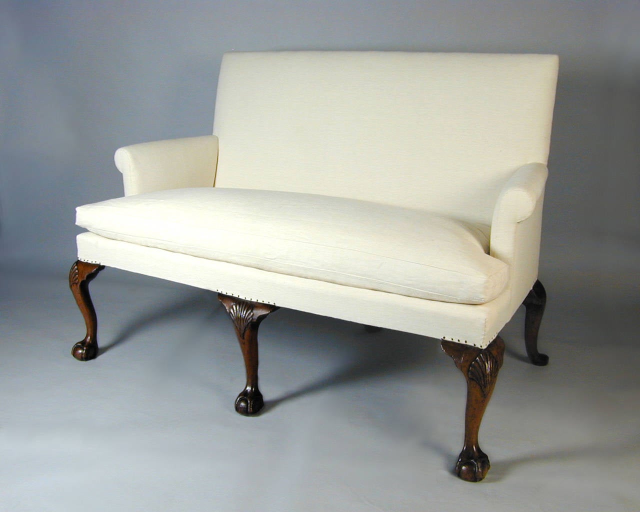 George II period walnut settee with shell-carved cabriole legs and claw and ball feet.