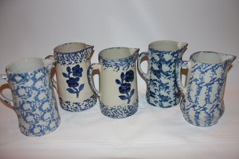Five Blue and Cream Spongeware jugs, two with floral print.
All same size